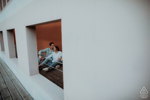 During their love session at Lyon Confluence Quai de Saone, the soon-to-be-married couple found themselves relaxing indoors, beautifully framed in a window opening with a minimalistic touch, capturing their love as they prepare to say "I do."