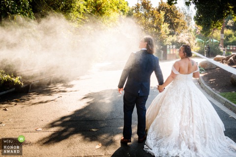 At a Victoria-AUS Zoo venue, the Bride and Groom are walking along when hit by a water sprayer