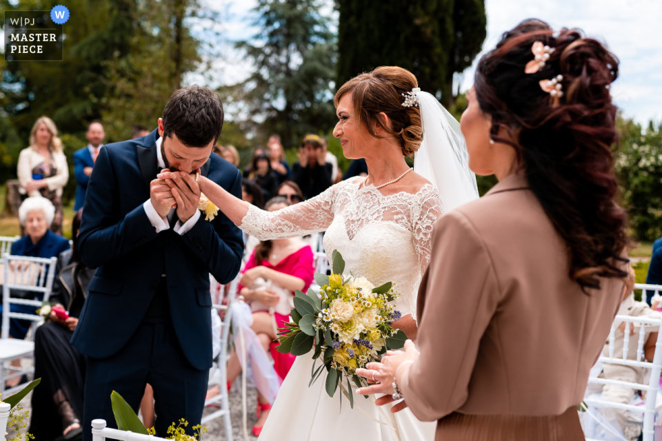 The newlyweds looked great together as the groom kissed the bride's hand at the outdoor ceremony at the beautiful Villa Iachia in Ruda, Udine, Italy
